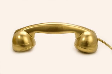 The telephone of gold colour on a white background.の写真素材