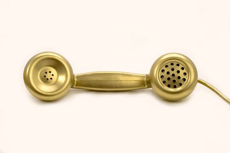 The telephone of gold colour on a white background.の写真素材