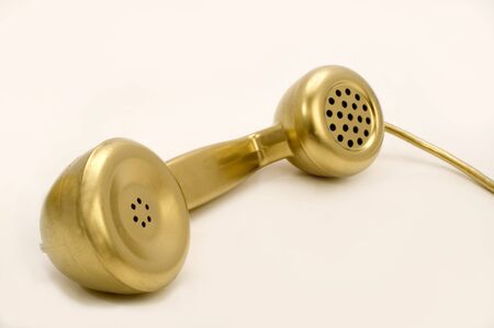 The telephone of gold colour on a white background.の写真素材