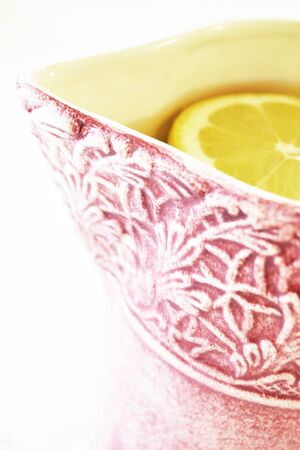 Pink pitcher with water and a lemonの写真素材