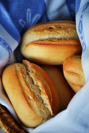 Bread rolls in a basket with a towelの写真素材