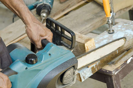 Man with chainsaw cutting the wood