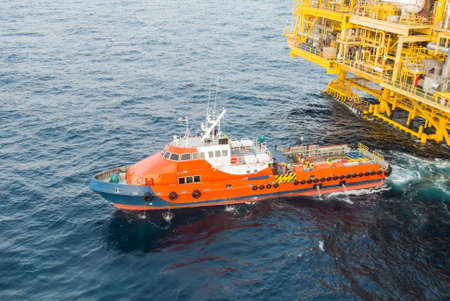 crew boat and oil platform yellow color in the seaのeditorial素材