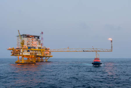 crew boat and oil platform yellow color in the seaのeditorial素材
