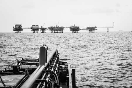 Oil platform process to black and white tank on back of supply boat