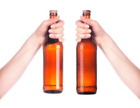 Frosty fresh bottle of beer in a hand isolated  making toast on a white backgroundの写真素材