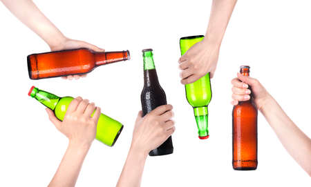 Frosty fresh bottle of beer in a hand set  isolated  making toast on a white backgroundの写真素材
