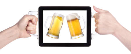 hands holding Touch screen tablet computer with beers making toastの写真素材