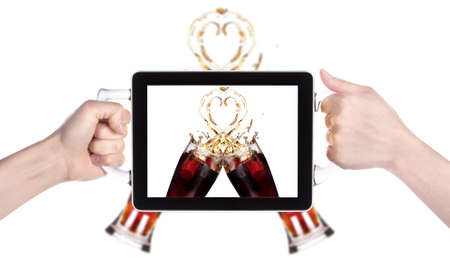 two fresh coke splash in digital tablet making a symbol of love isolated on whiteの写真素材