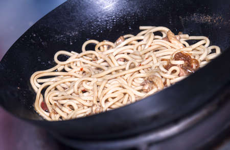 Stir fry noodle with chicken in a wok panの写真素材