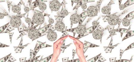 Financial crisis - an old bombs made of money and hands showing home signの写真素材