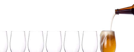 leader concept - empty and one full beer glass isolated on a white backgroundの写真素材