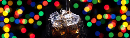 party background with fresh splashing cola full of ice cubes on a blackの写真素材