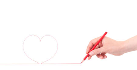 woman hand with pencil draws the heart, isolated on a white backgroundの写真素材