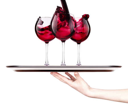 celebrate the holiday background - hand with red splashing wine on a silver trayの写真素材