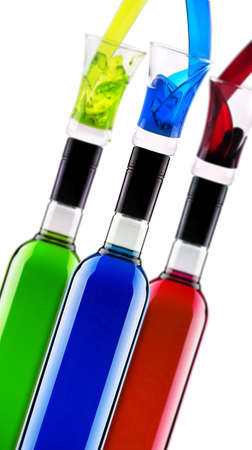 full bottles of different multicolored alcoholic cocktails with glass isolatedの写真素材
