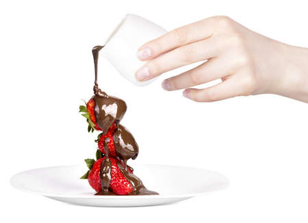 strawberries and chocolate with hand on a white backgroundの写真素材
