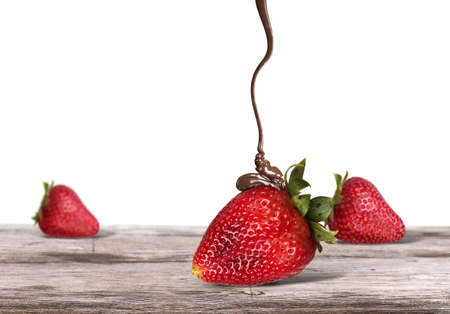 strawberries and chocolate on a wooden table isolatedの写真素材