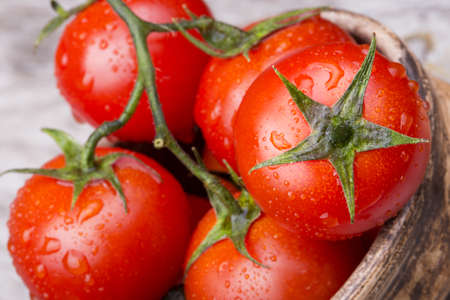 Cherry tomatoes on wooden table with water dropsの写真素材