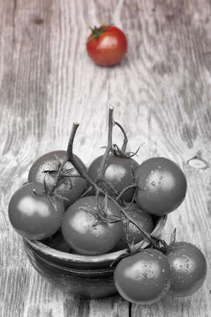 Cherry tomatoes on wooden table with water dropsの写真素材