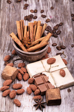 white cup of espresso full of coffee with Chocolate bar and spices on wooden tableの写真素材