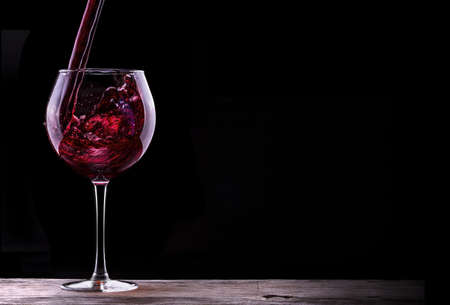 Elegant red wine glass in black backgroundの写真素材
