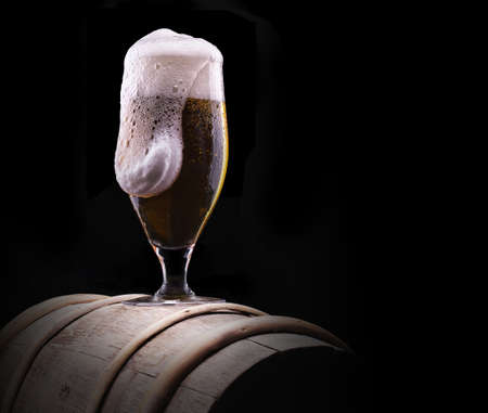 Frosty glass of light beer on black backgroundの写真素材