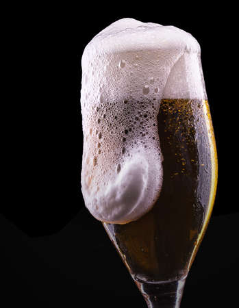 Frosty glass of light beer on black backgroundの写真素材