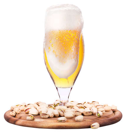 Frosty glass of light beer with pistachos isolated on a white backgroundの写真素材