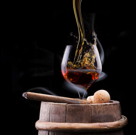 Cognac glass shrouded in a smoke on a black backgroundの写真素材