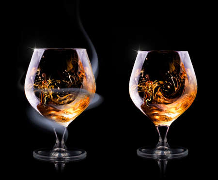 Cognac glass shrouded in a smoke on a black backgroundの写真素材