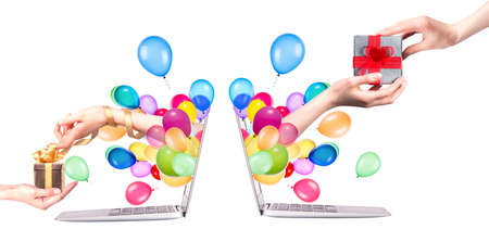 hand with a gift and balloons come out from a screen of a laptop computer isolated on white backgroundの写真素材