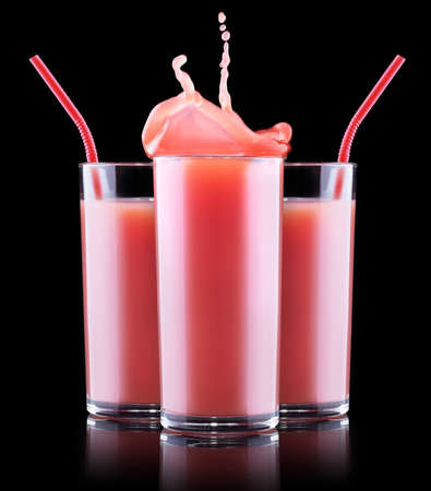 Smoothies of strawberry in glass with splash isolated on a black backgroundの写真素材