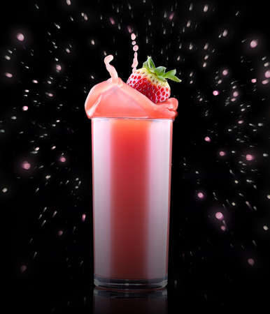 Smoothies of strawberry in glass with splash isolated on a black backgroundの写真素材