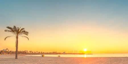 Barceloneta Beach in Barcelona with colorful sky at sunriseの写真素材