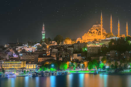 Istanbul skyline from Galata bridge by night, with Suleymaniye mosque and fish boat ferryの写真素材