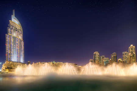 The night cityscape with dancing fountain of Dubai, UAEの写真素材