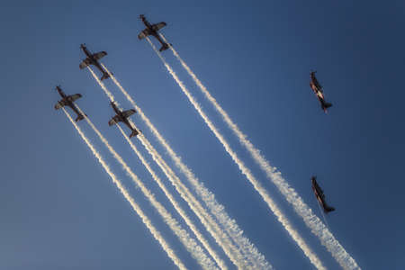 Reactive jet plane flying in formation and leave inversion trail on blue skyの写真素材
