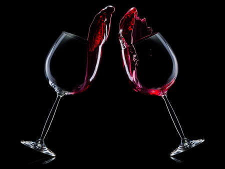 Set of red wine glasses with splashes isolated on blackの写真素材
