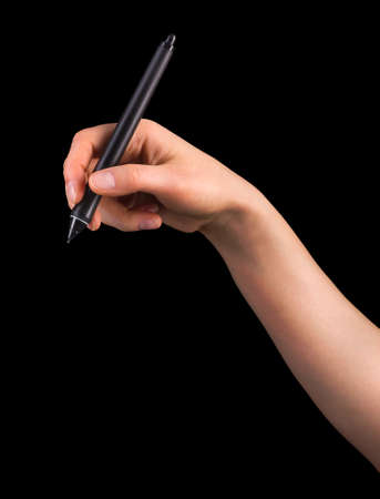 Hand holding digital graphic pen and drawing something isolated on blackの写真素材
