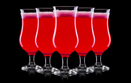Set of strawberry cocktails in hurricane glass isolated on black background.