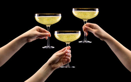 Set of hands holding glass of sparkling champagne isolated on black.