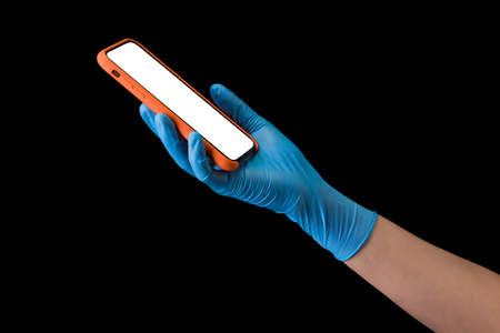 Doctors hand in medical gloves holding phone isolated on black