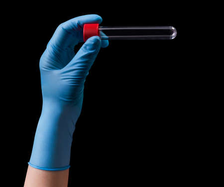 Doctor's hand in medical gloves holding test tube with coronavirus COVID-19 isolated on black background. Concept of protection against pandemic and viruses.の写真素材