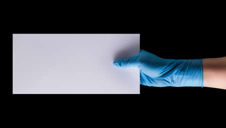 Doctor's hand in sterile medical gloves holding banner isolated on black background with clipping path. Concept of protection against pandemic and massage Stay at home.の写真素材