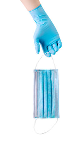 Doctor's hand in medical gloves holding mask isolated on white background . Concept of protection...