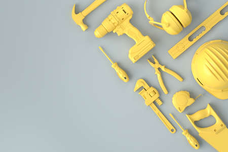 Top view of monochrome construction tools for repair on grey and yellow