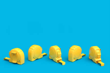 Set of yellow carpenter measuring tape isolated on blue background with imperial units scale. 3d render and illustration of tool for repair and buildingの写真素材