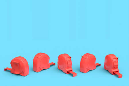 Set of red carpenter measuring tape isolated on blue background with imperial units scale. 3d render...