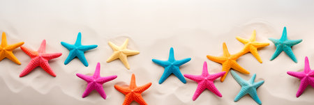 Colorful starfish is scattered across the sandy beach, in the style of minimalist backgrounds. Summer concept.の素材